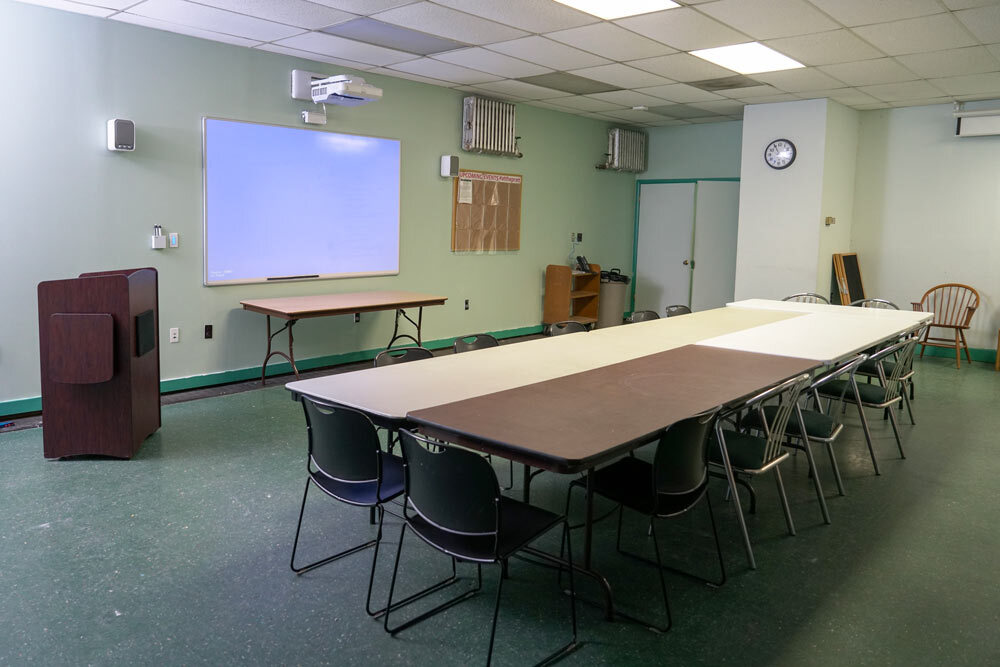 Forest Park meeting room with tables, chairs, and digital projection screen