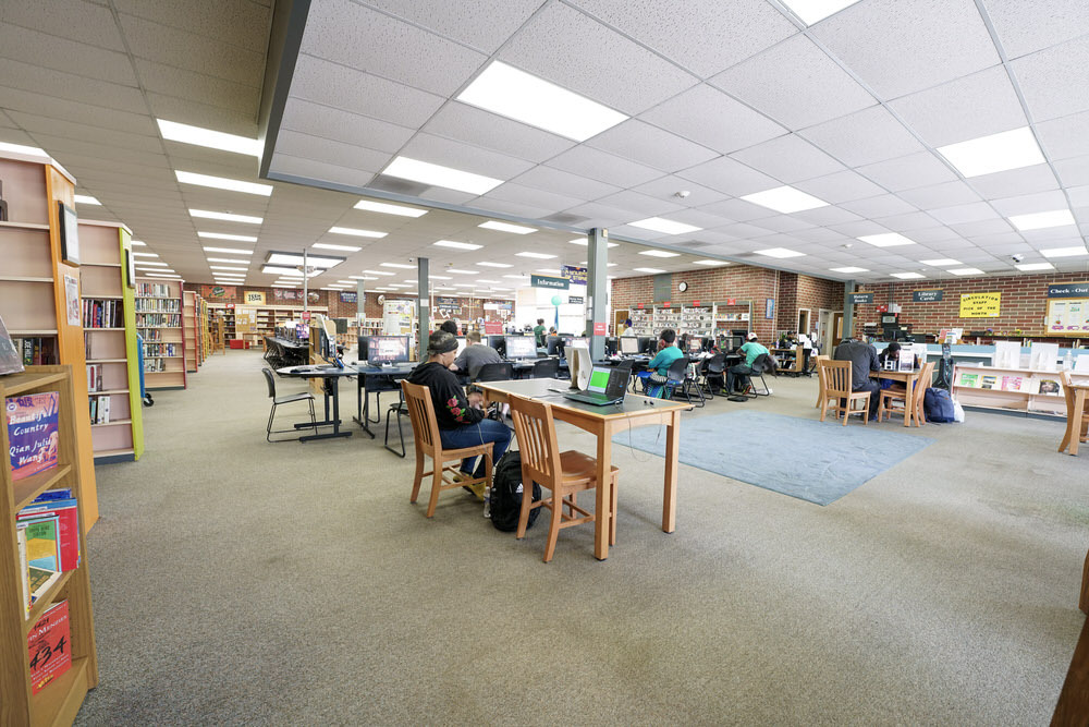 Hamilton Branch interior - wide room view with tables, bookshelves, people