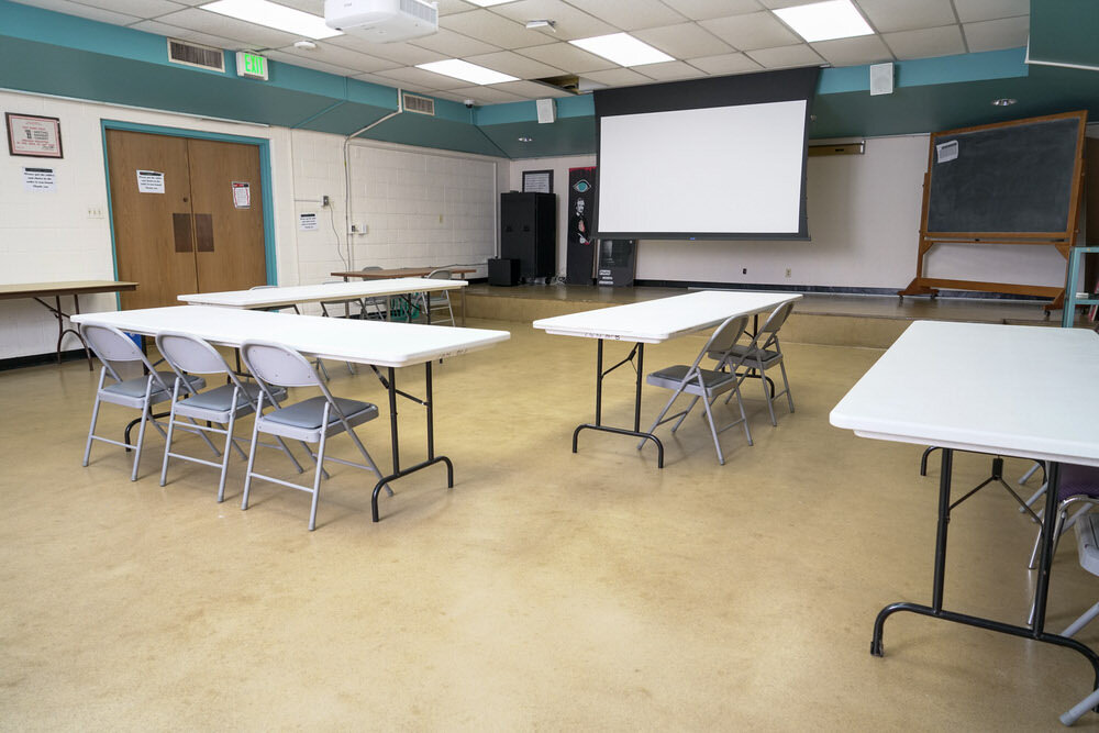 Light Street meeting room - tables and chairs, screen, chalkboard, doors corner view
