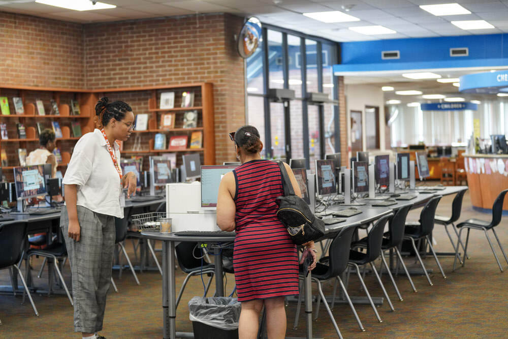 Northwood Branch staff assisting a person by computers