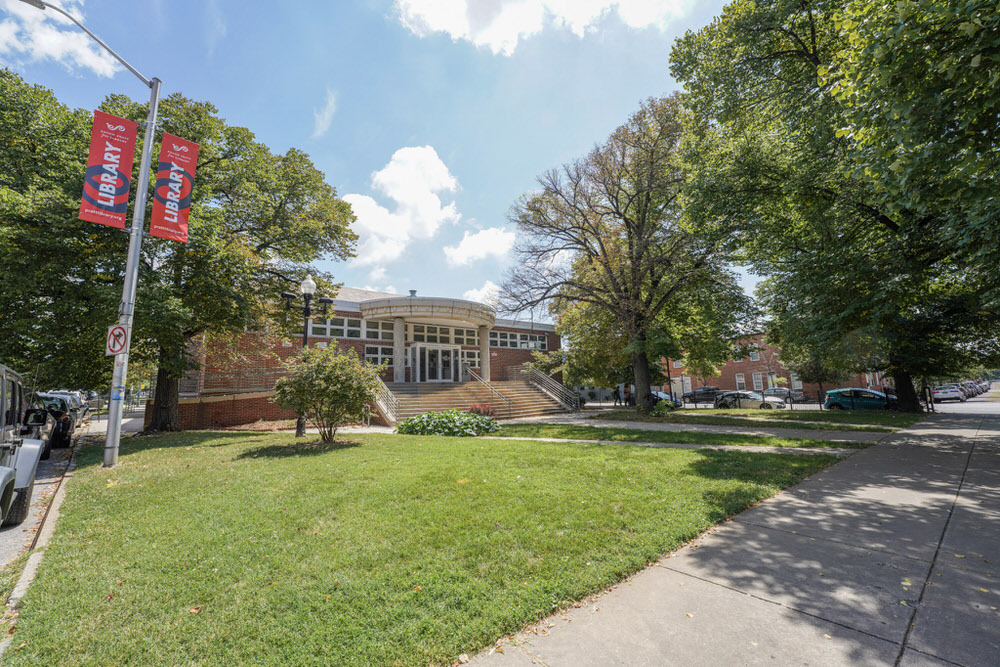 Patterson Park Branch showing red library flags by green grass and trees