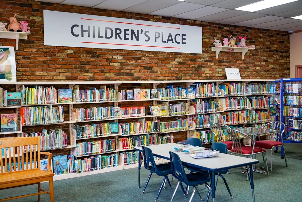 Washington Village Children's Place showing kids' books, seating, and toys on the wall