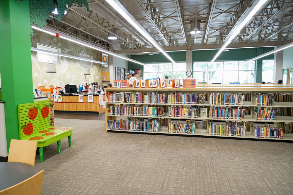 Waverly bookshelves, windows, and children's section with a tree design and bench painted with apples